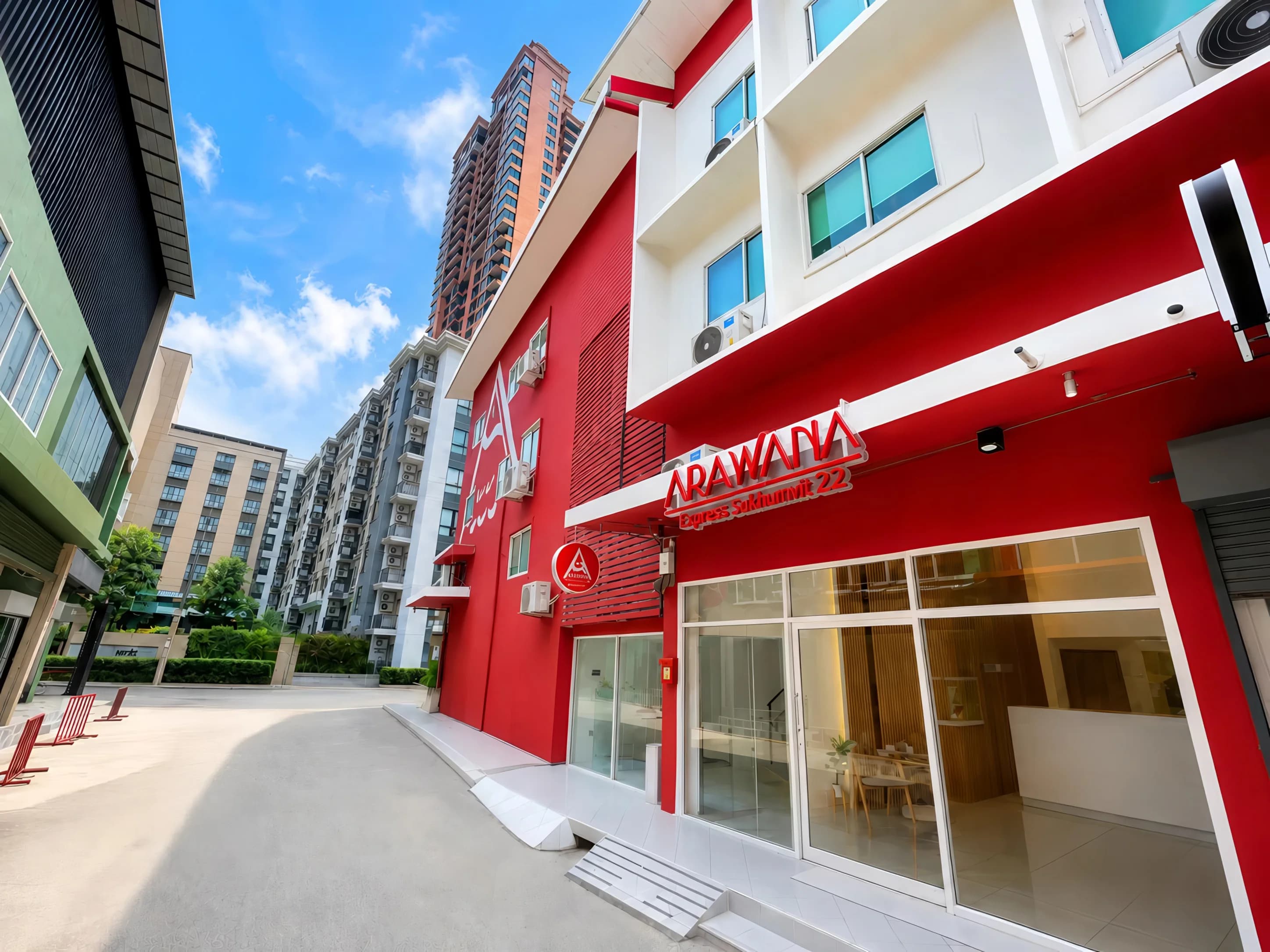 The red facade and glass entrance of Arawana Express Sukhumvit 22 on Soi 22