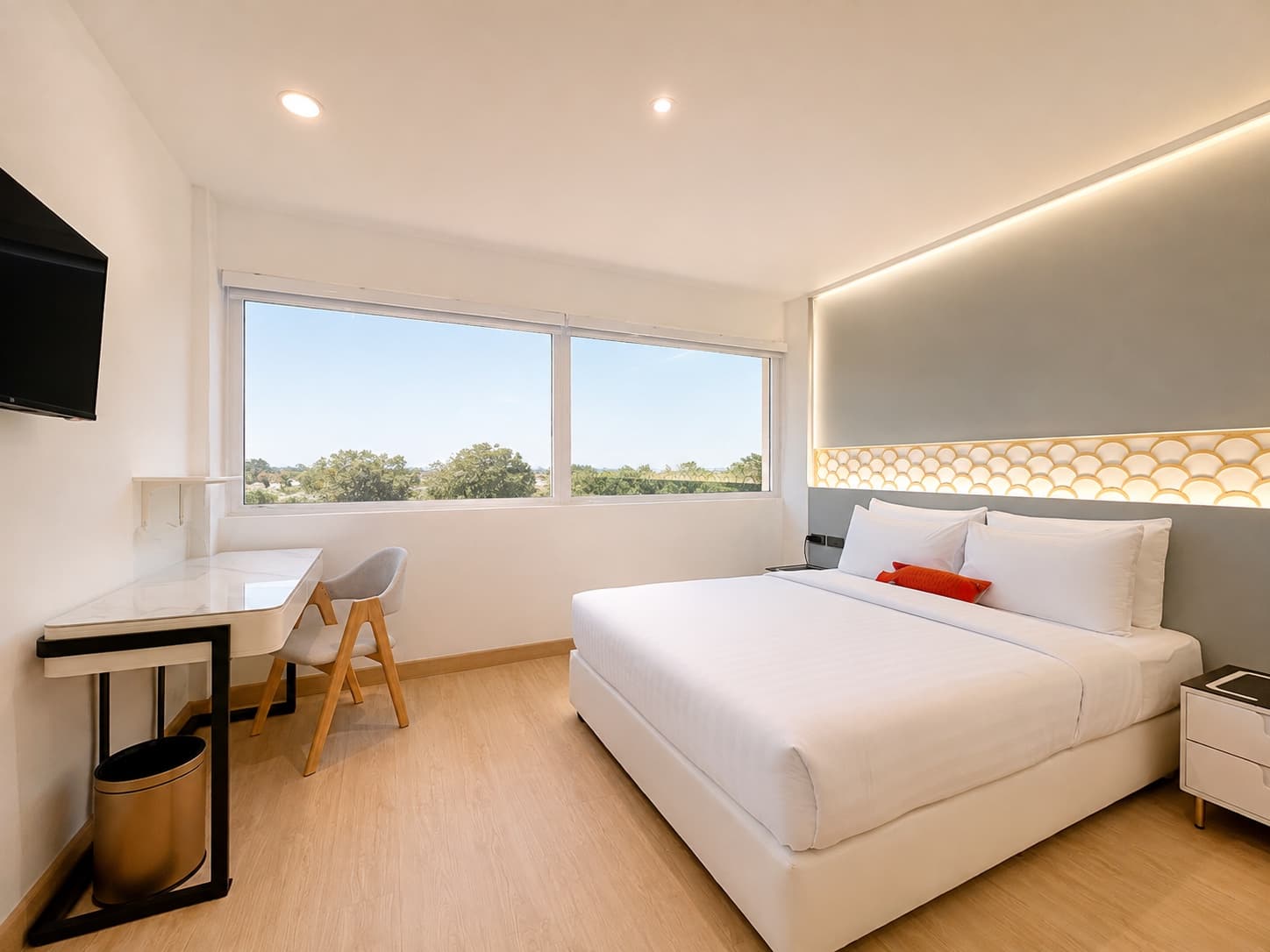 A bright king room with a desk and wide window at Arawana Express Sukhumvit 22