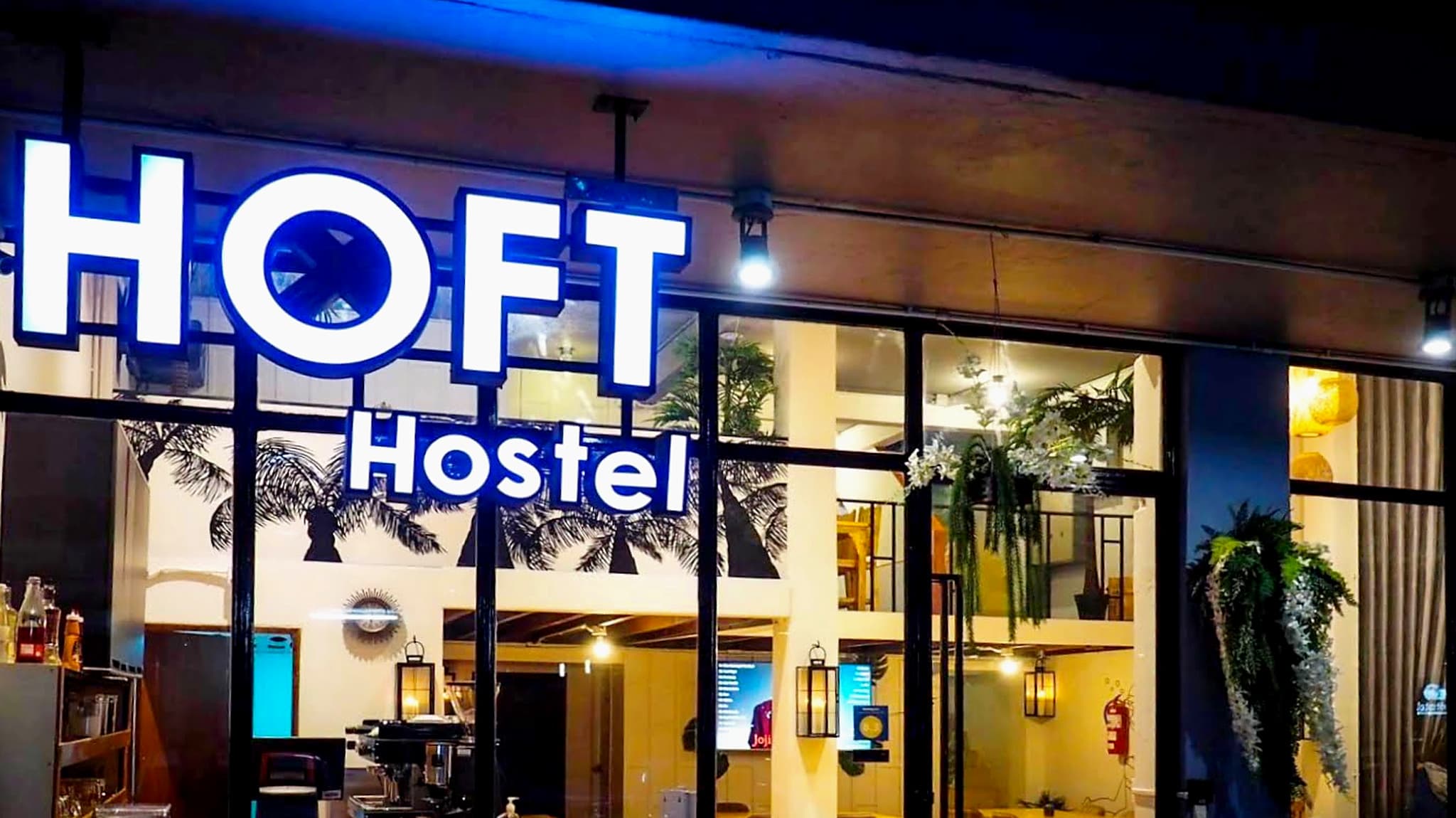 The entrance to Arawana HOFT Hostel in Silom, Bangkok, lit at night