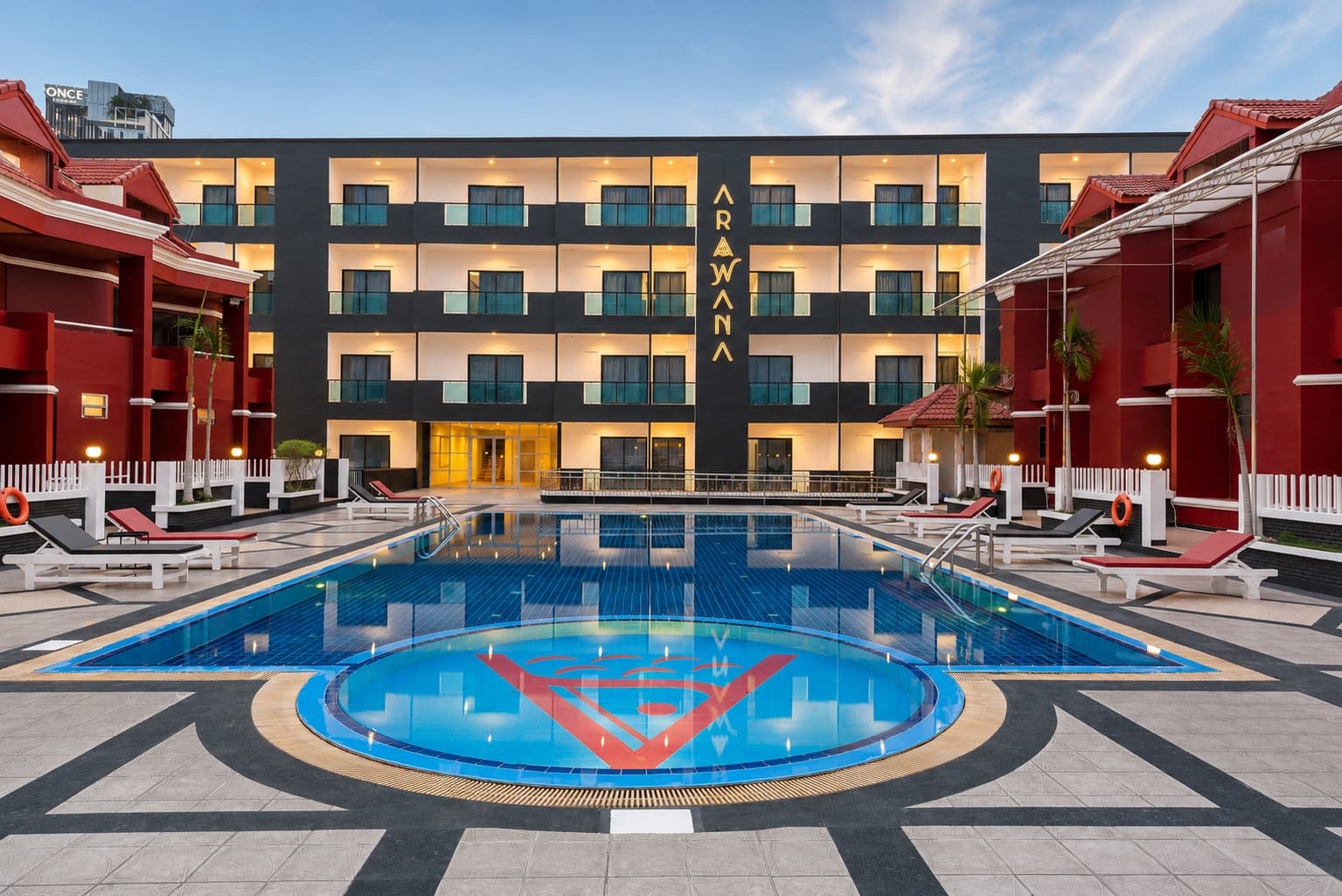 The courtyard pool and red facade of Arawana Regency North Pattaya on a sunny day