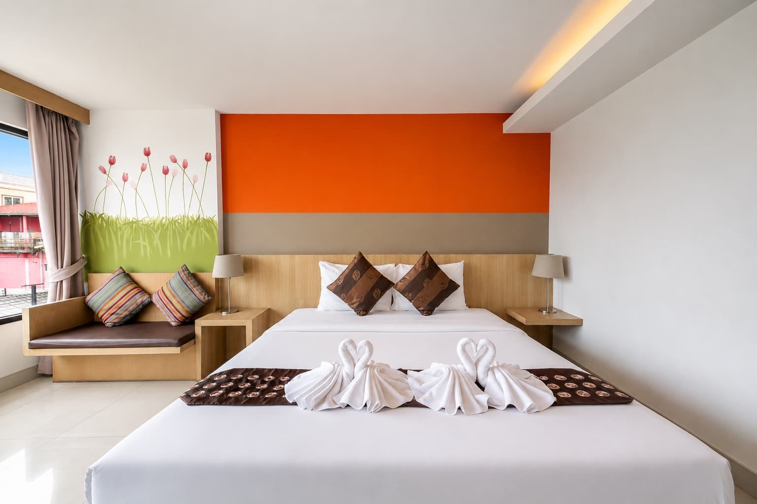A king room with an orange feature wall and window seat at Arawana Regency South Pattaya