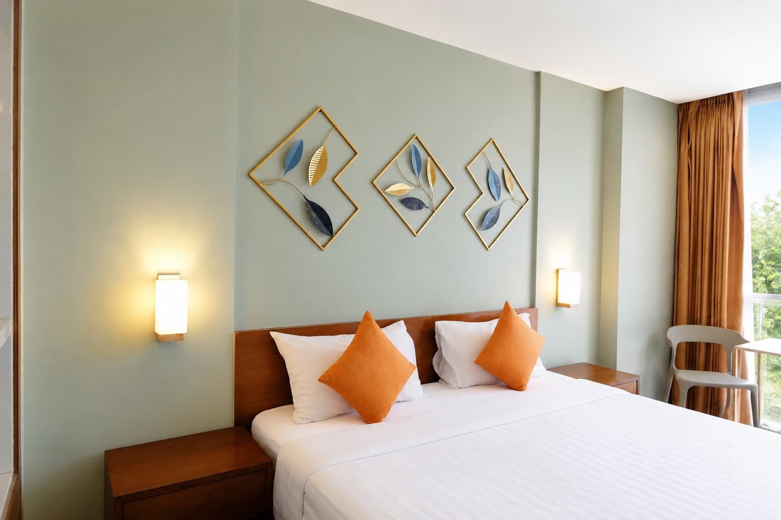 A bedroom with orange cushions and leaf artwork above the bed at an Arawana property.