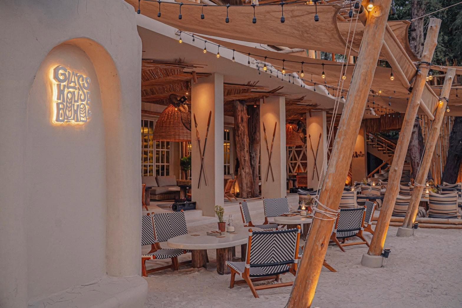 Lantern-lit tables on the sand under canvas sails at The Glass House, Na Jomtien