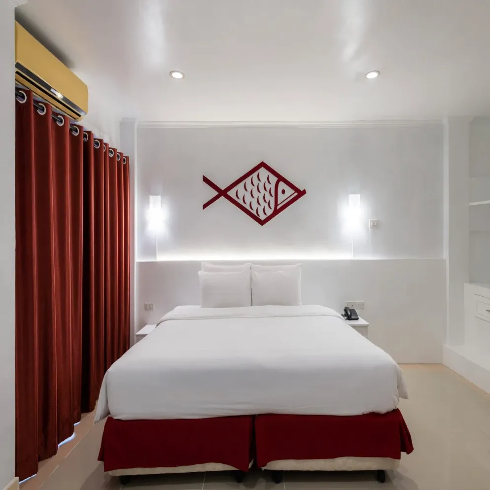 A family room at Arawana Express North Pattaya, the Arawana fish emblem above the bed